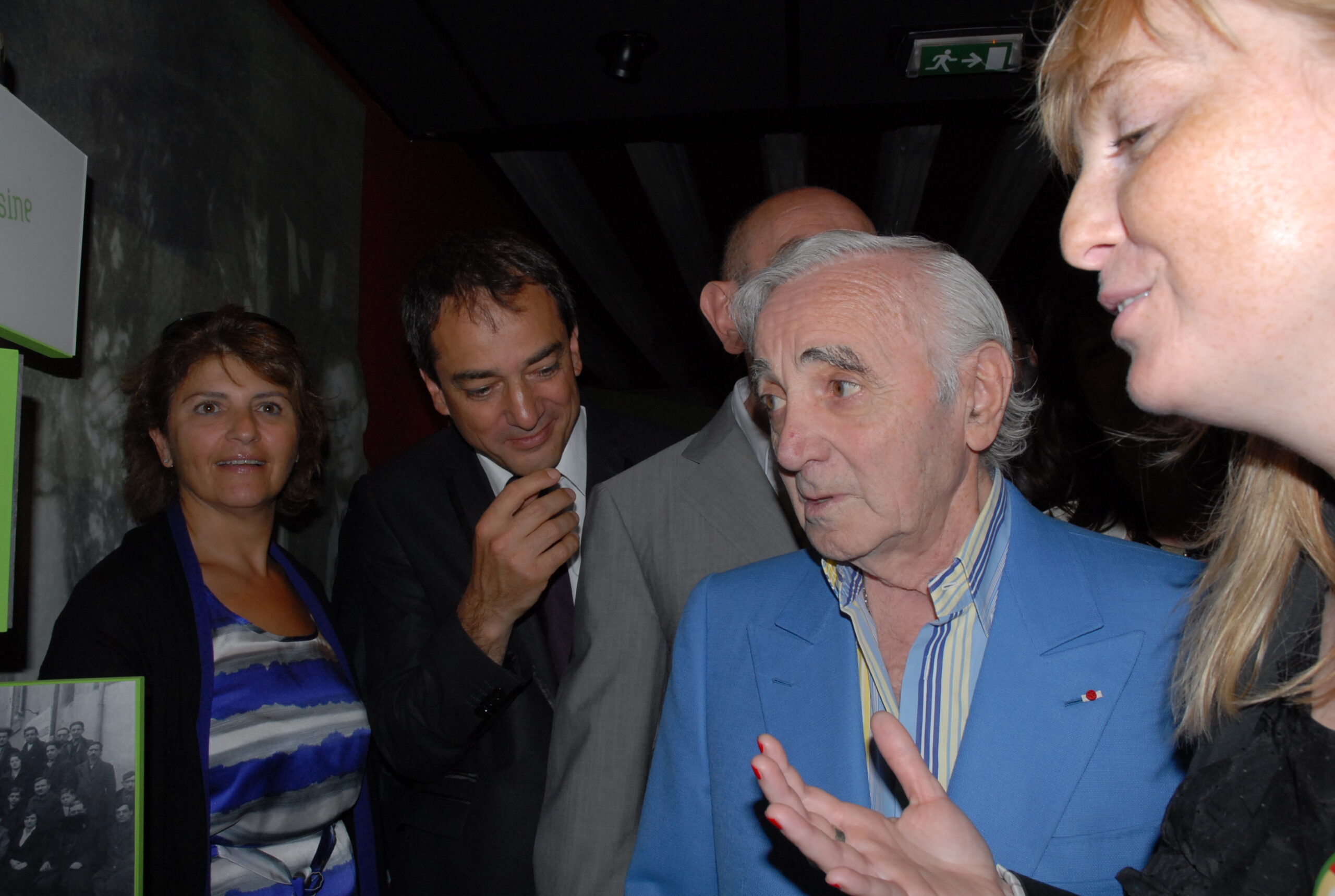 Charles Aznavour écoute la directrice du Centre